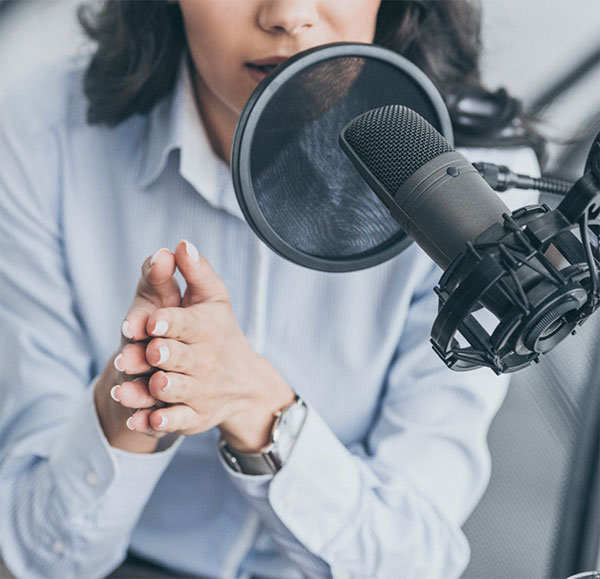 Woman talking into podcast microphone